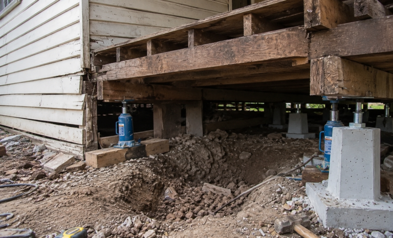 House foundation supported by jacks during a grounding near me service in Melbourne.